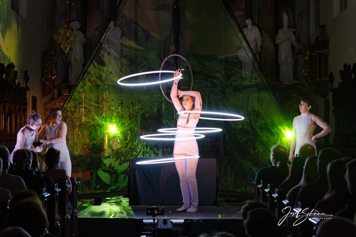 Hula Hoops im grün beleuchteten Kirchenraum.